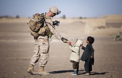 militar servindo comida a crianças necessitadas